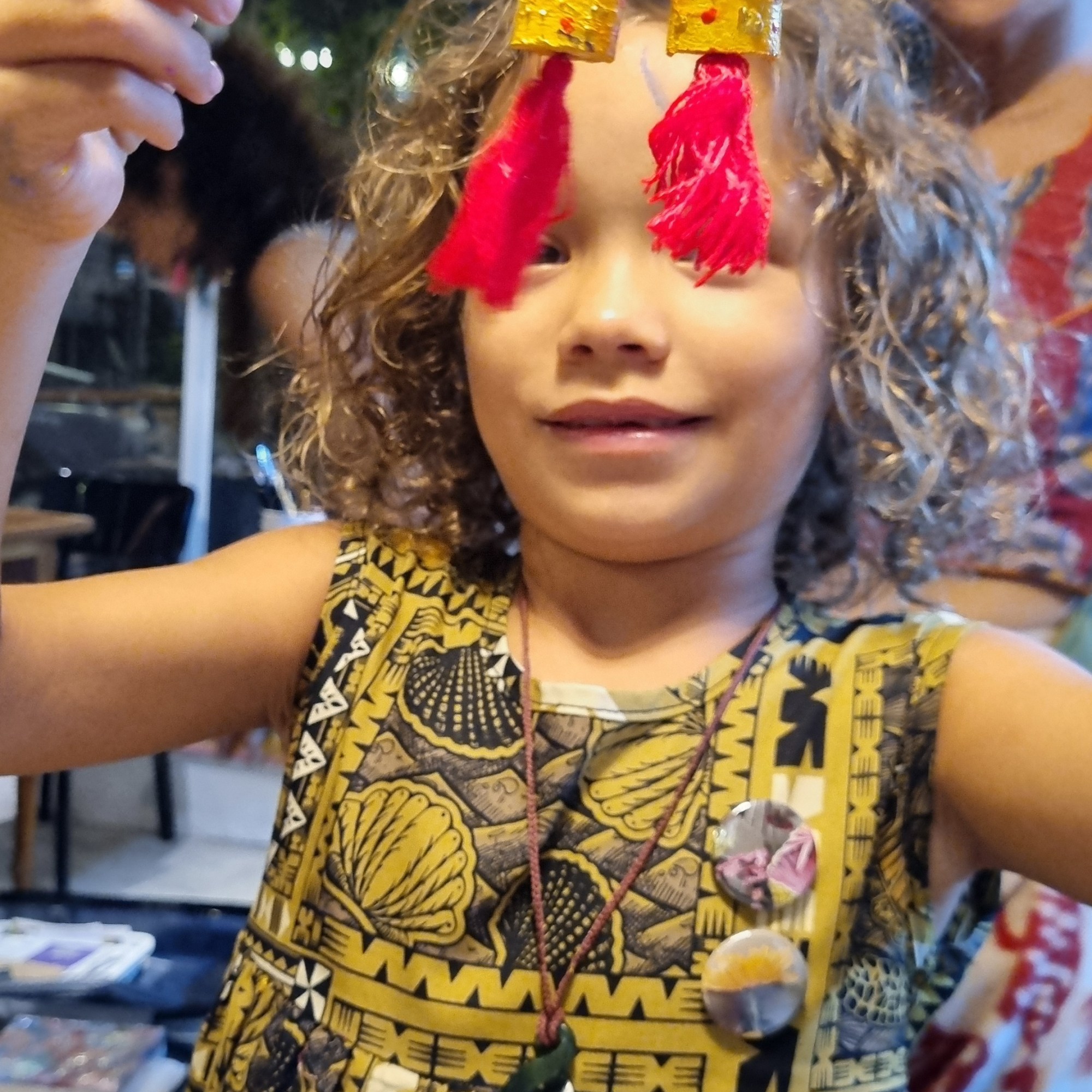 A little kid making her own earrings with Rubynnastory.