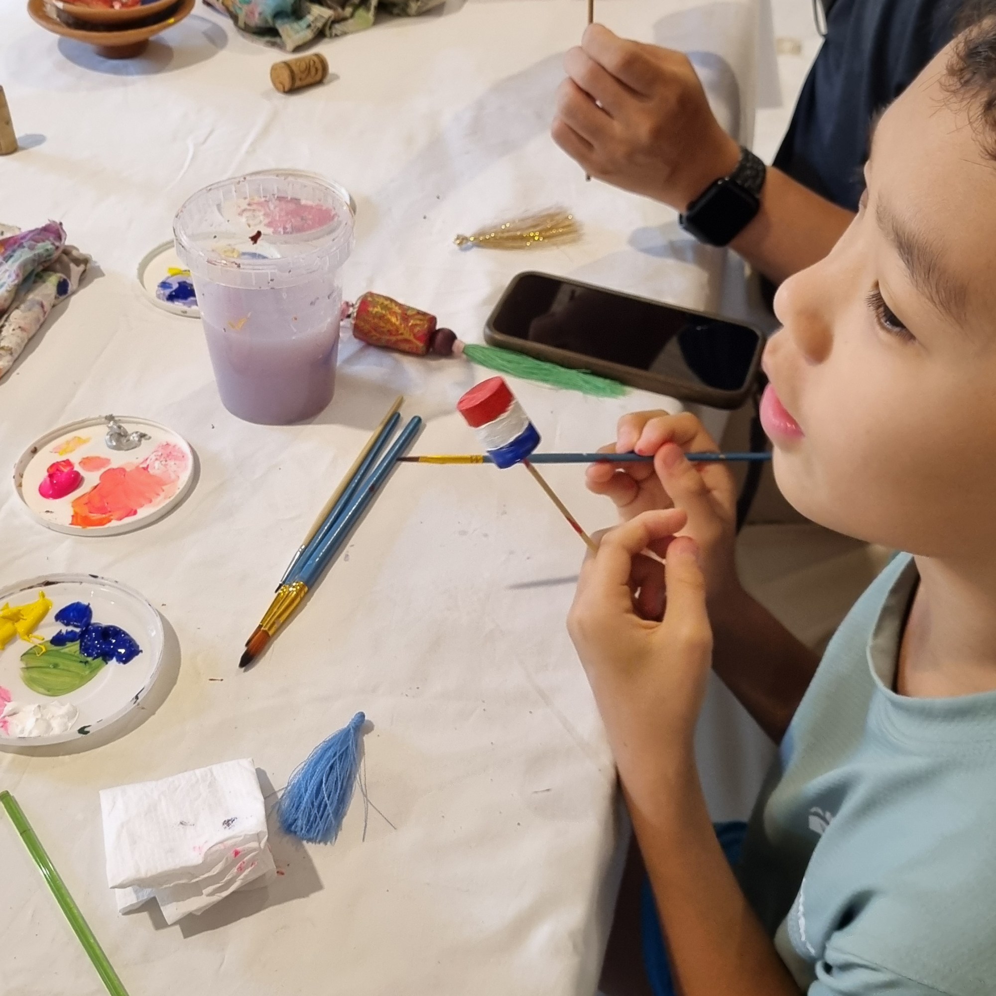 A father and son making keychains with Rubynnastory in Bangkok.